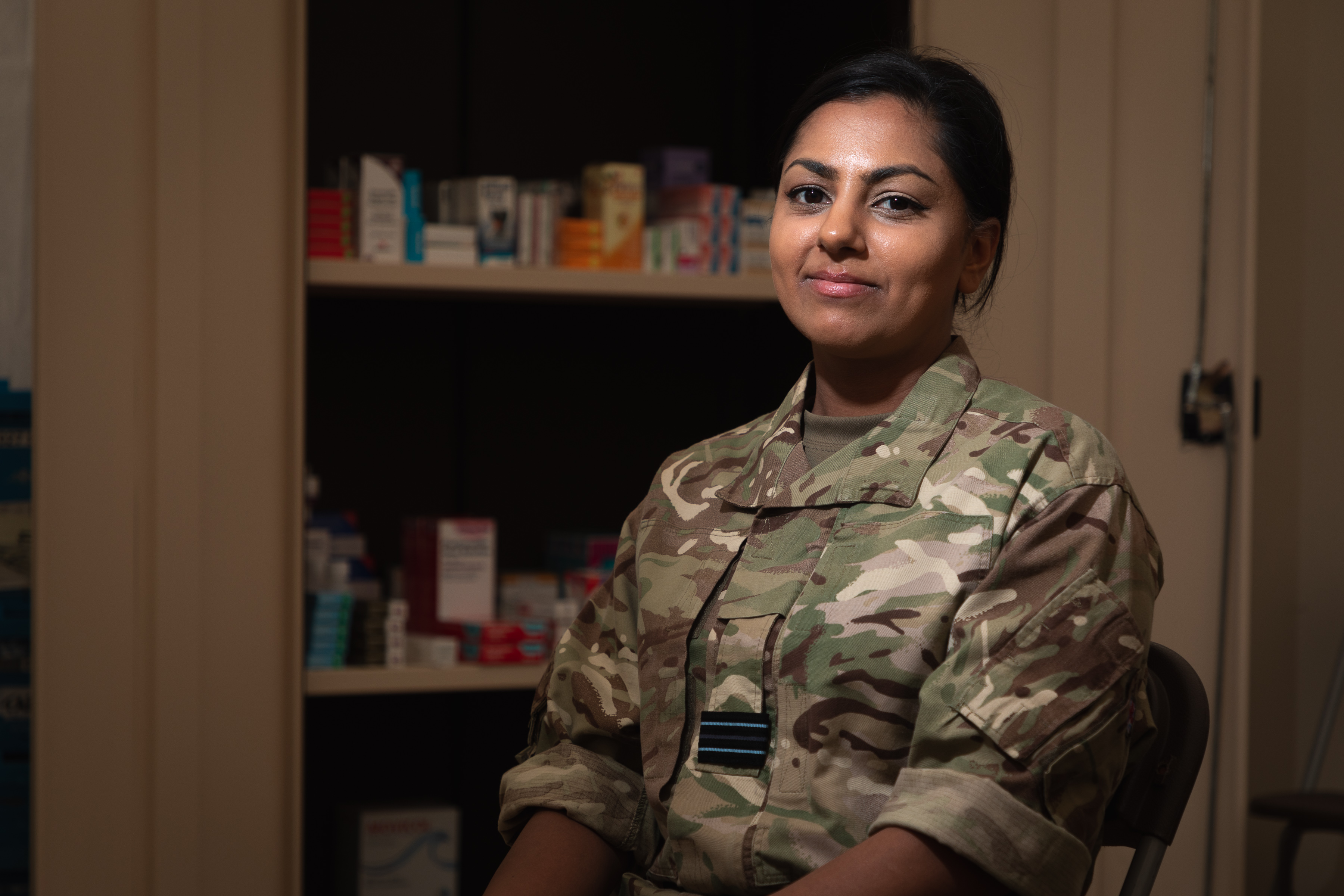 Image shows RAF aviator sitting in front of a pharmacy medicine cabinet.